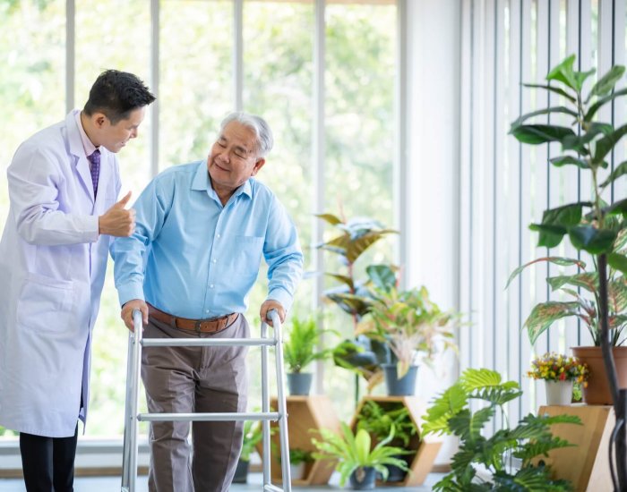 Orthopedic doctor and senior patient with walker at nursing home
